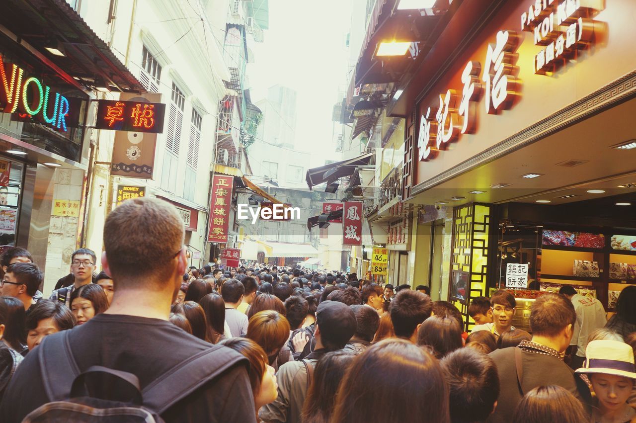 REAR VIEW OF PEOPLE AT MARKET