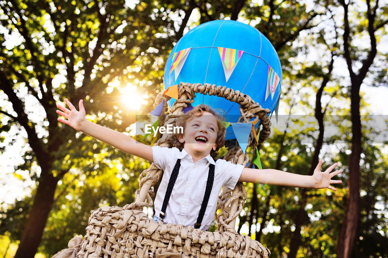 Happy boy standing in hot air balloon