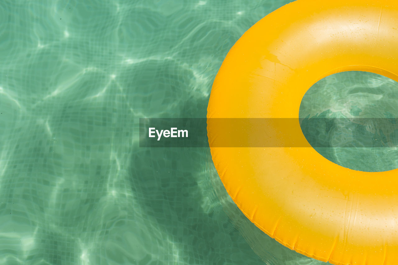 High angle view of yellow inflatable raft in swimming pool