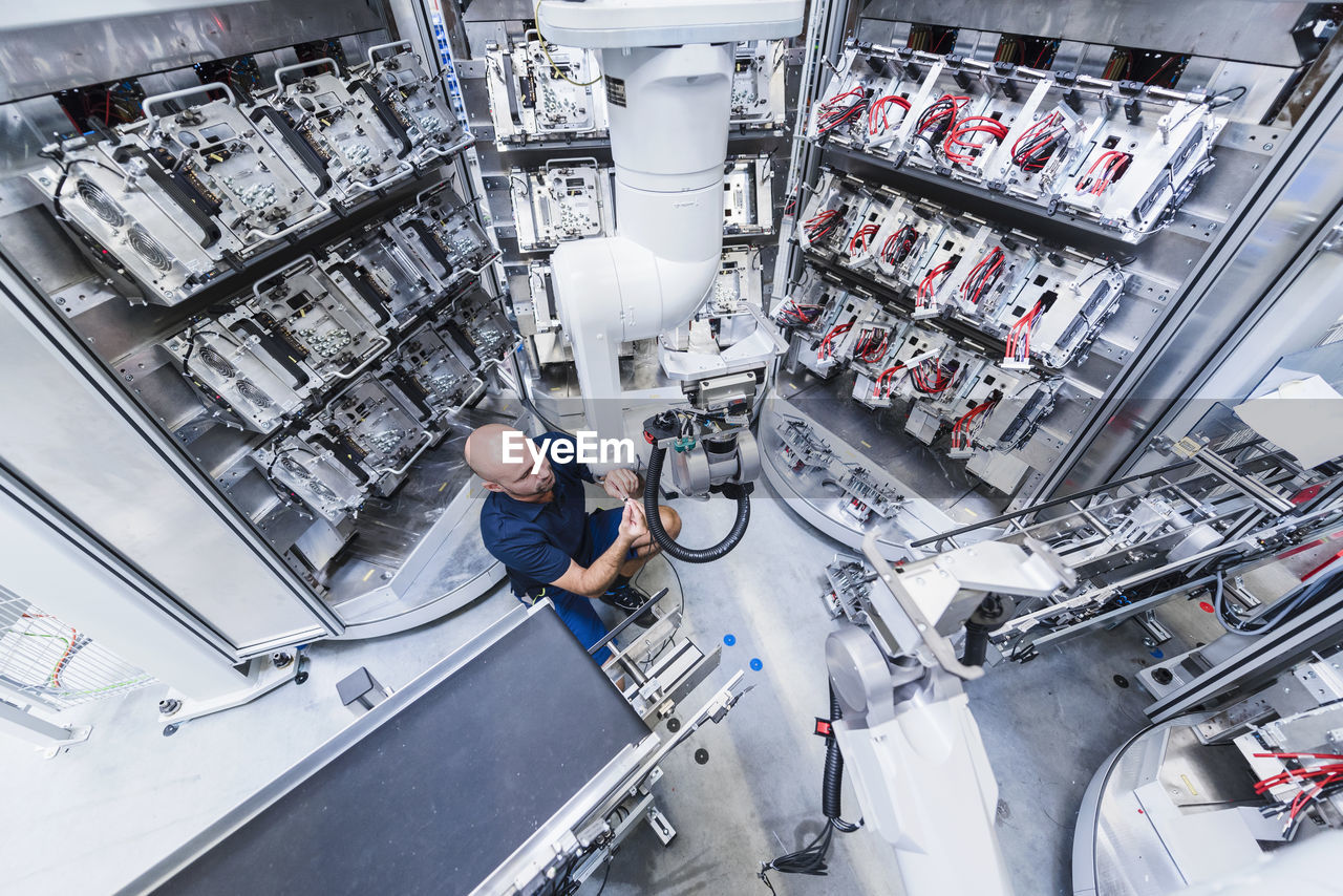 Man working at industrial robot in modern factory