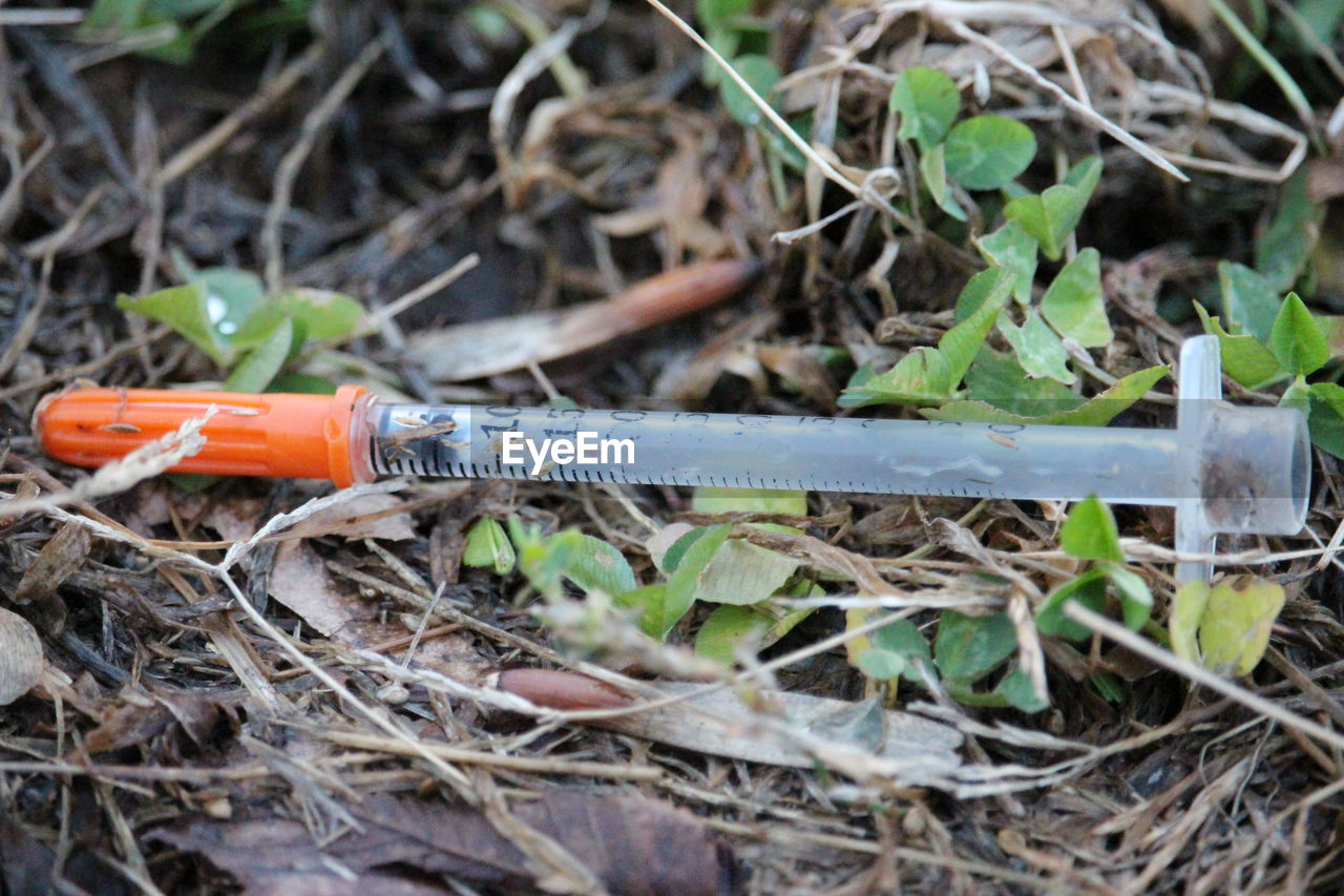 Close-up of syringe on messy field