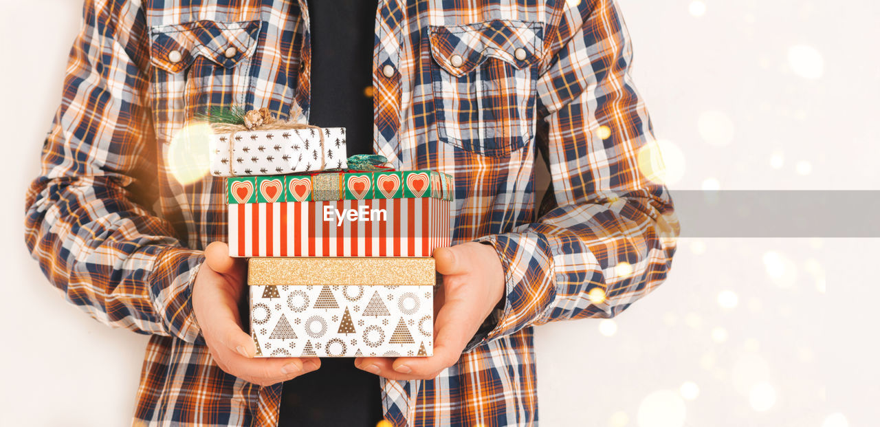 A man in a shirt holds various gift boxes. christmas and holiday concept. copy space