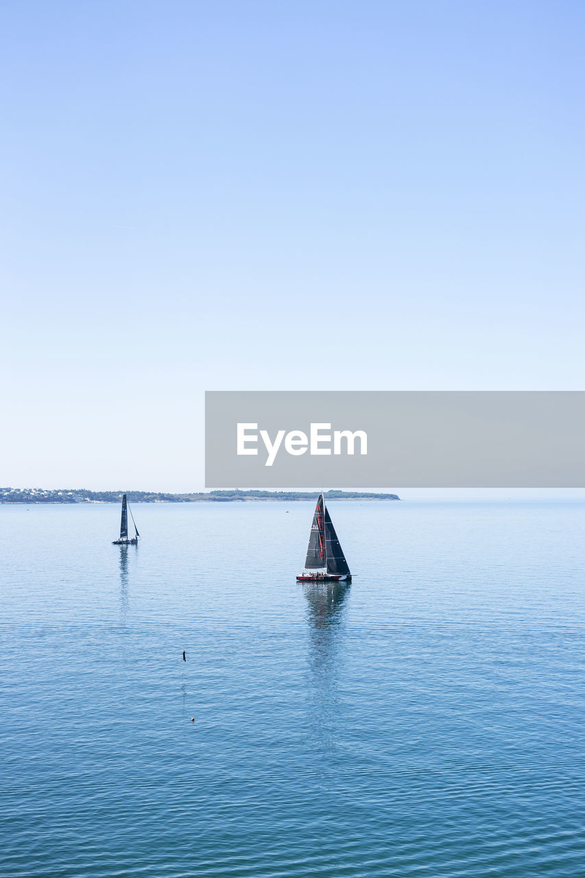 BOAT SAILING IN SEA AGAINST CLEAR SKY