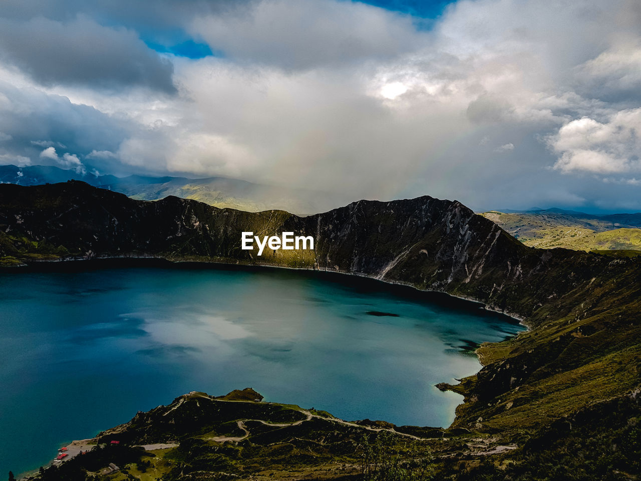 Scenic view of lake by mountains against sky
