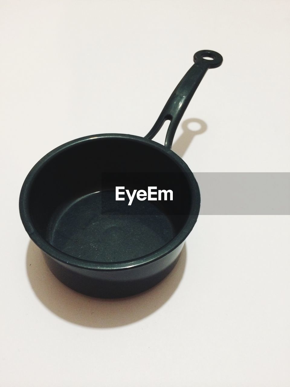 Empty black saucepan against white background