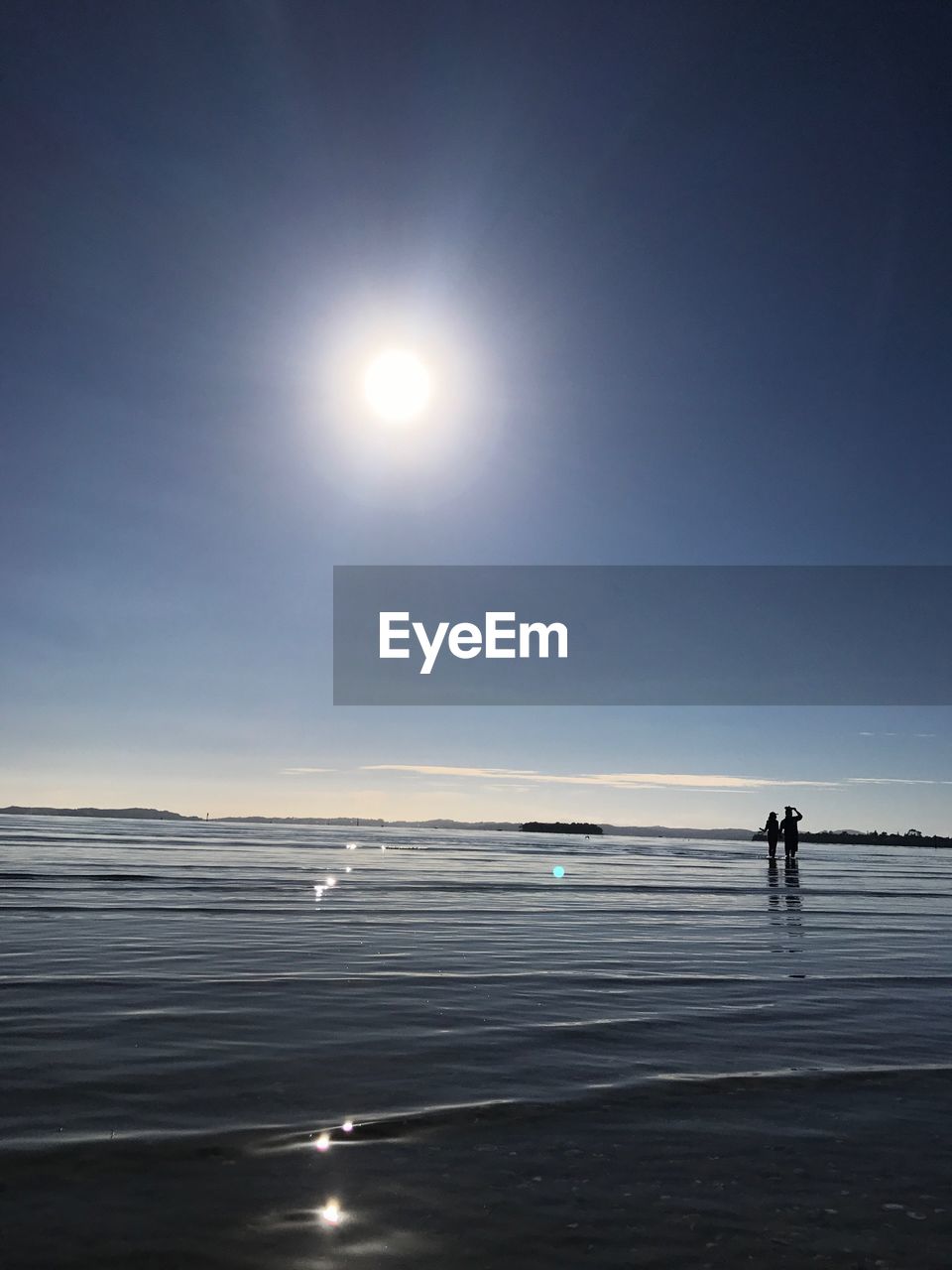 SILHOUETTE OF PEOPLE ON BEACH AGAINST SKY