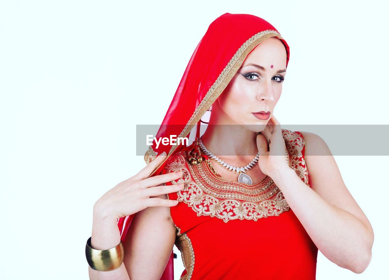 Portrait of beautiful woman in traditional clothing against white background