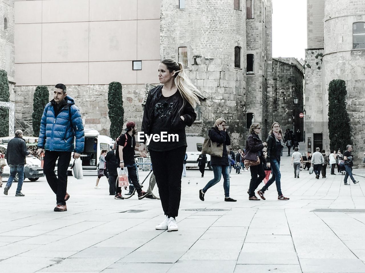 FULL LENGTH OF YOUNG WOMAN WALKING ON CITY STREET