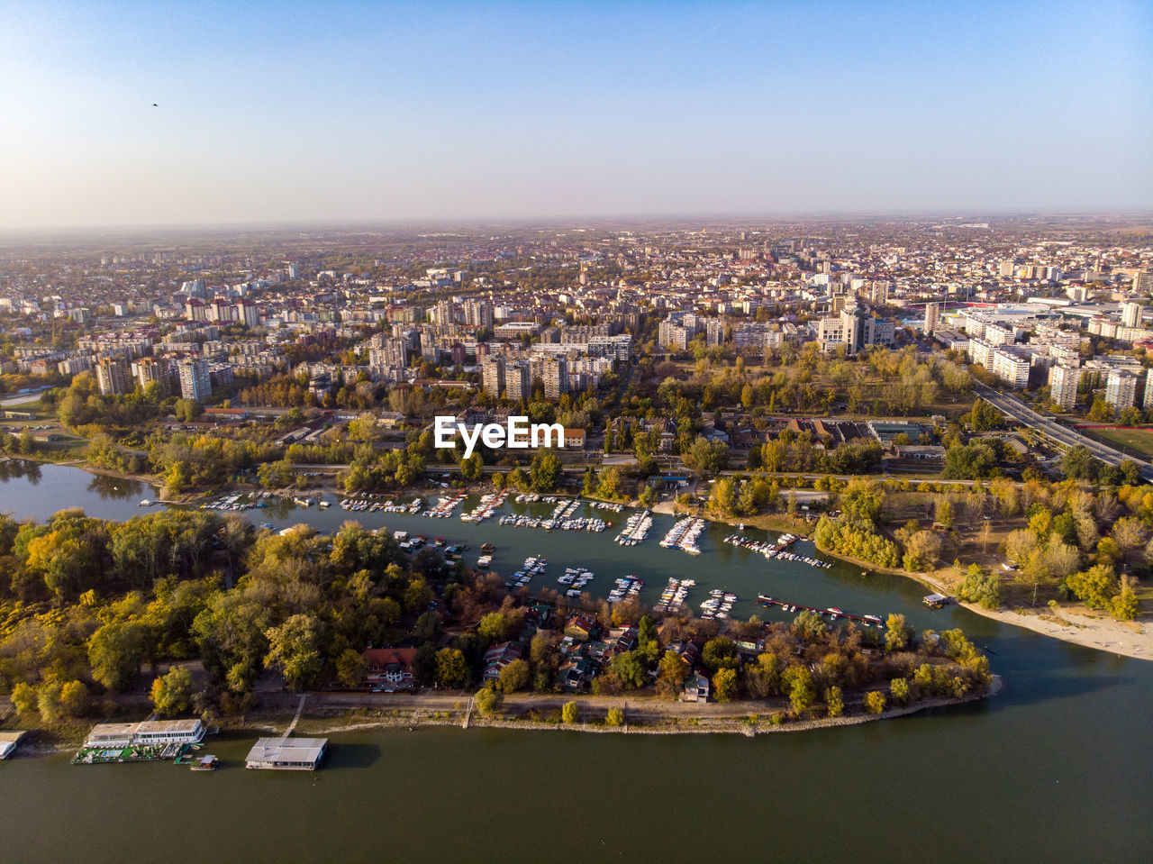 HIGH ANGLE VIEW OF BUILDINGS BY RIVER AGAINST SKY
