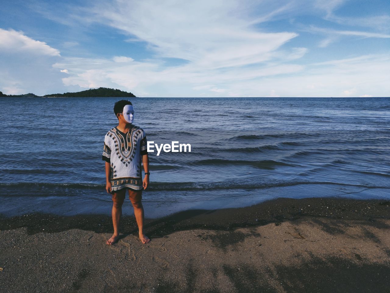 Young man wearing mask while standing at beach