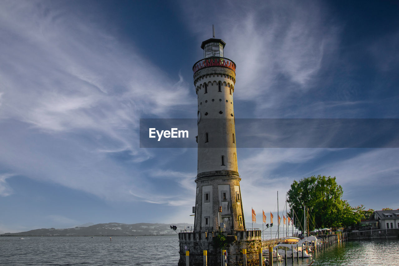 Lighthouse by sea against sky