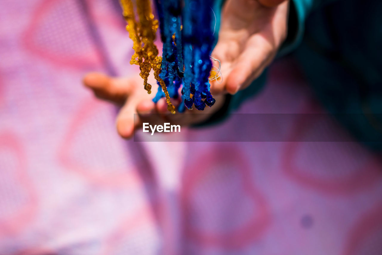 Close-up of hand holding beads