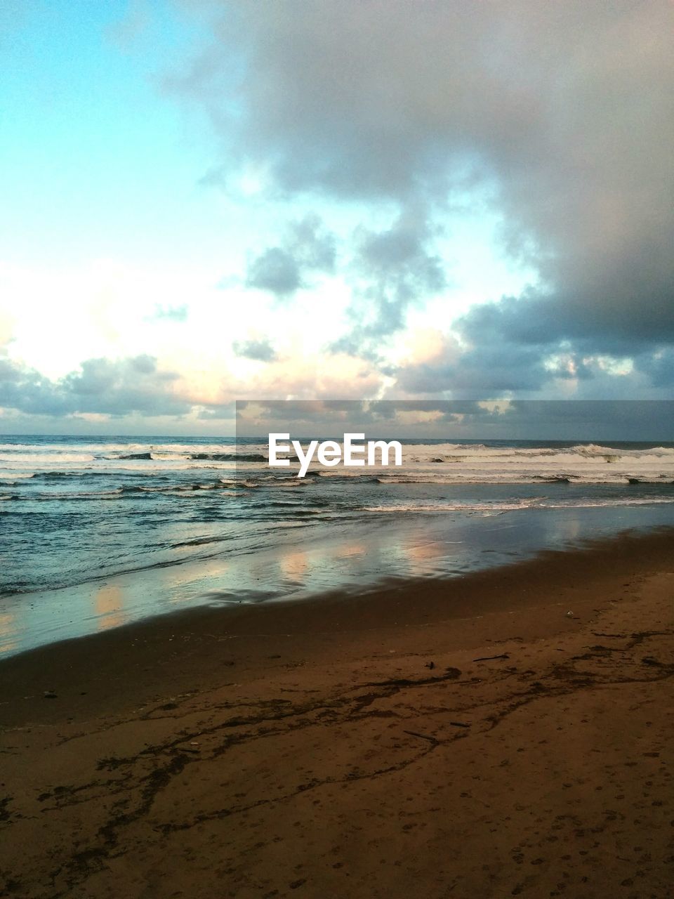 Scenic view beach against cloudy sky