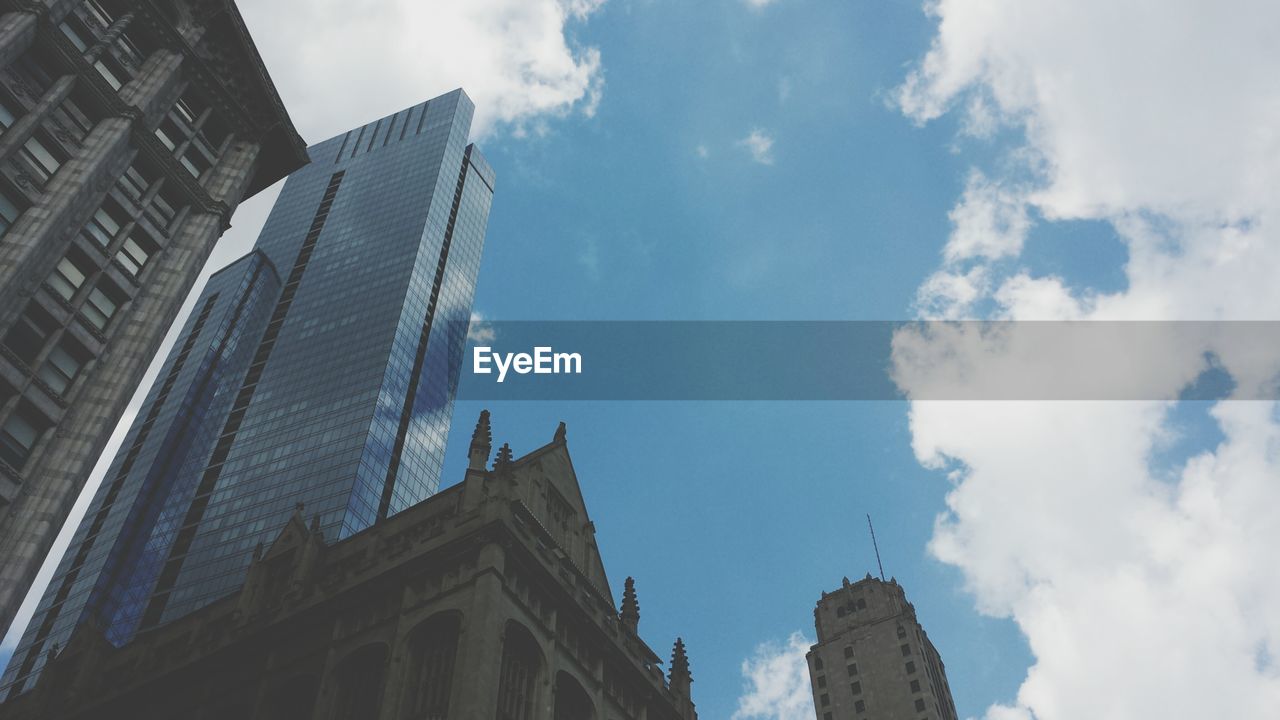 Low angle view of modern building against cloudy sky