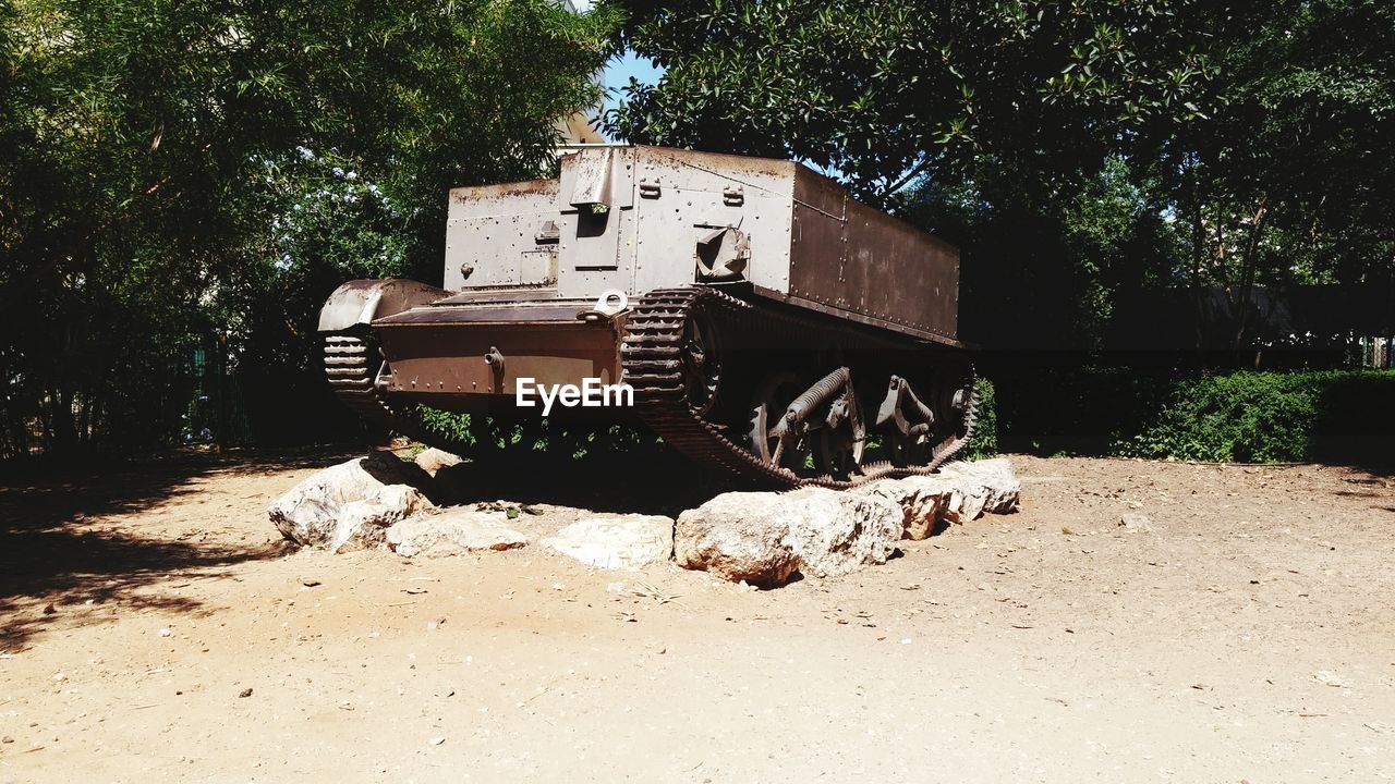 Abandoned armored tank by trees in forest