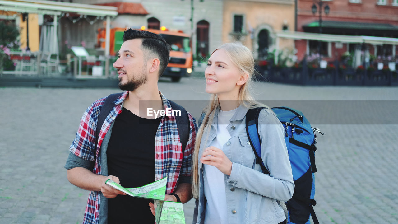 YOUNG COUPLE STANDING ON STREET