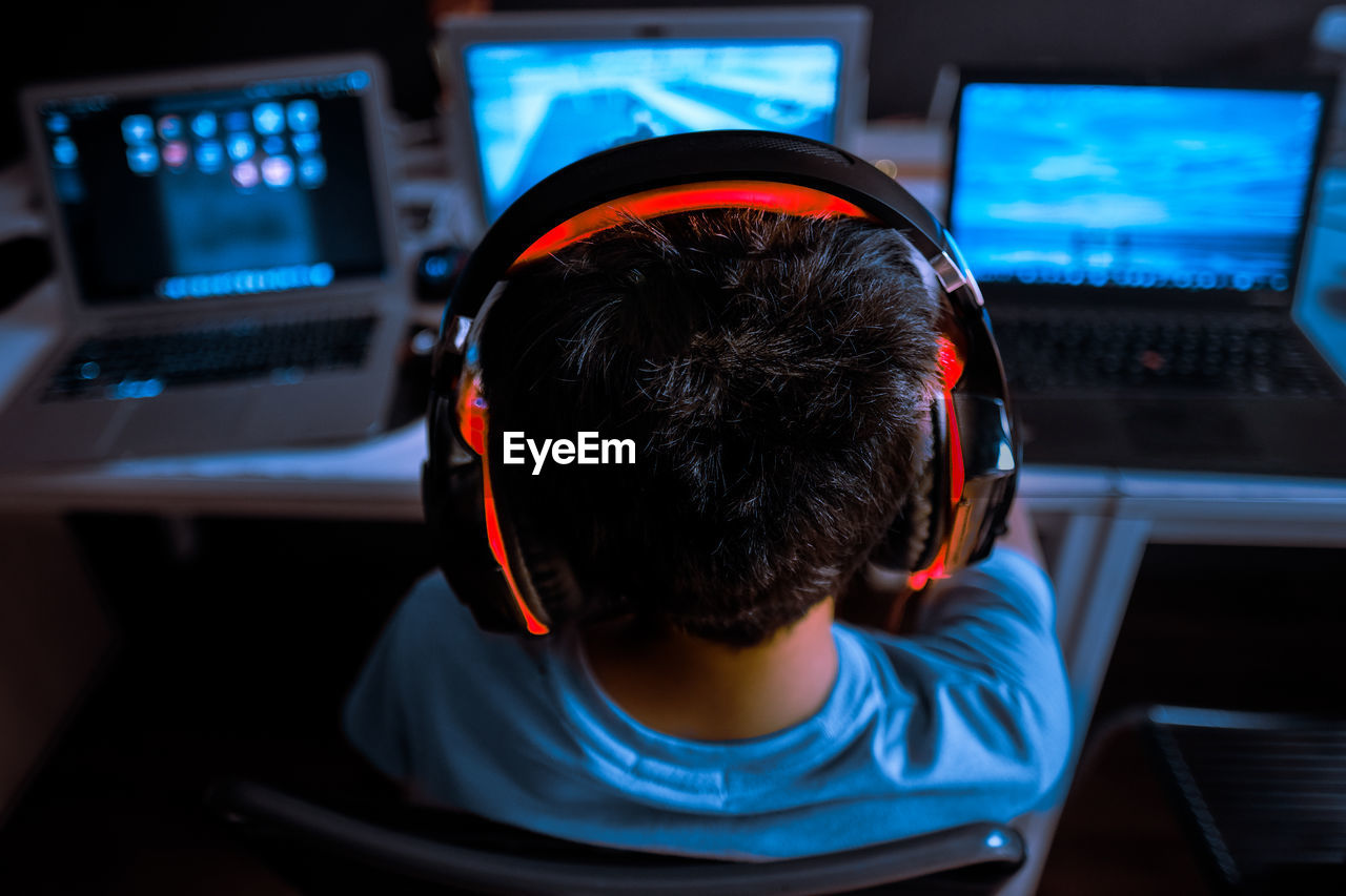 Rear view of boy paying video game