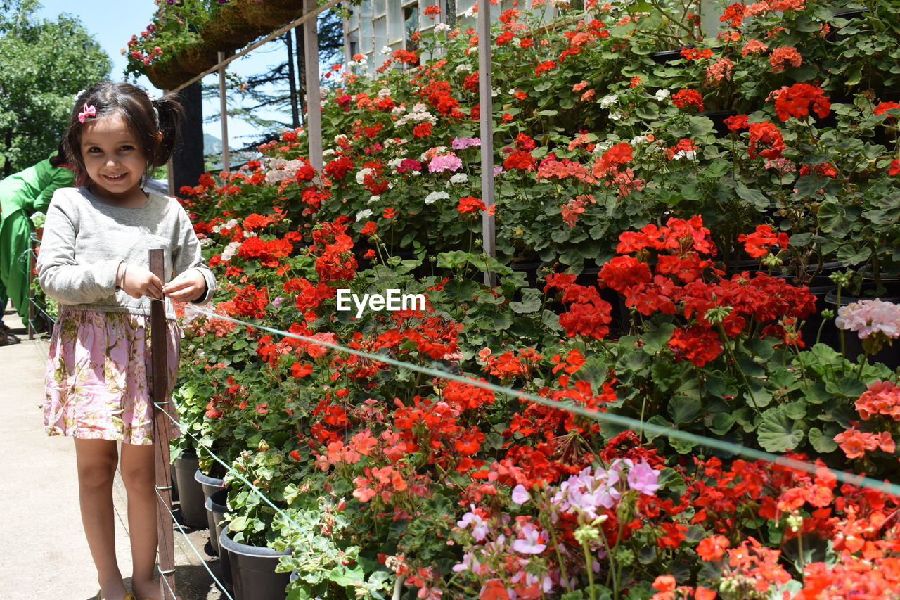 Portrait of smiling girl standing by flower shop