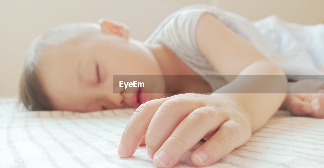 CLOSE-UP OF BABY BOY SLEEPING IN BED