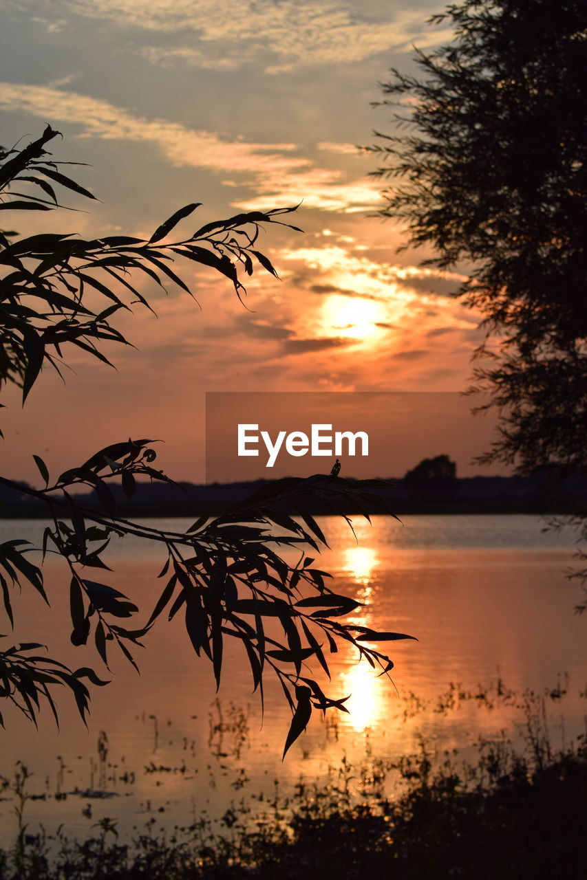 Scenic view of lake against orange sky