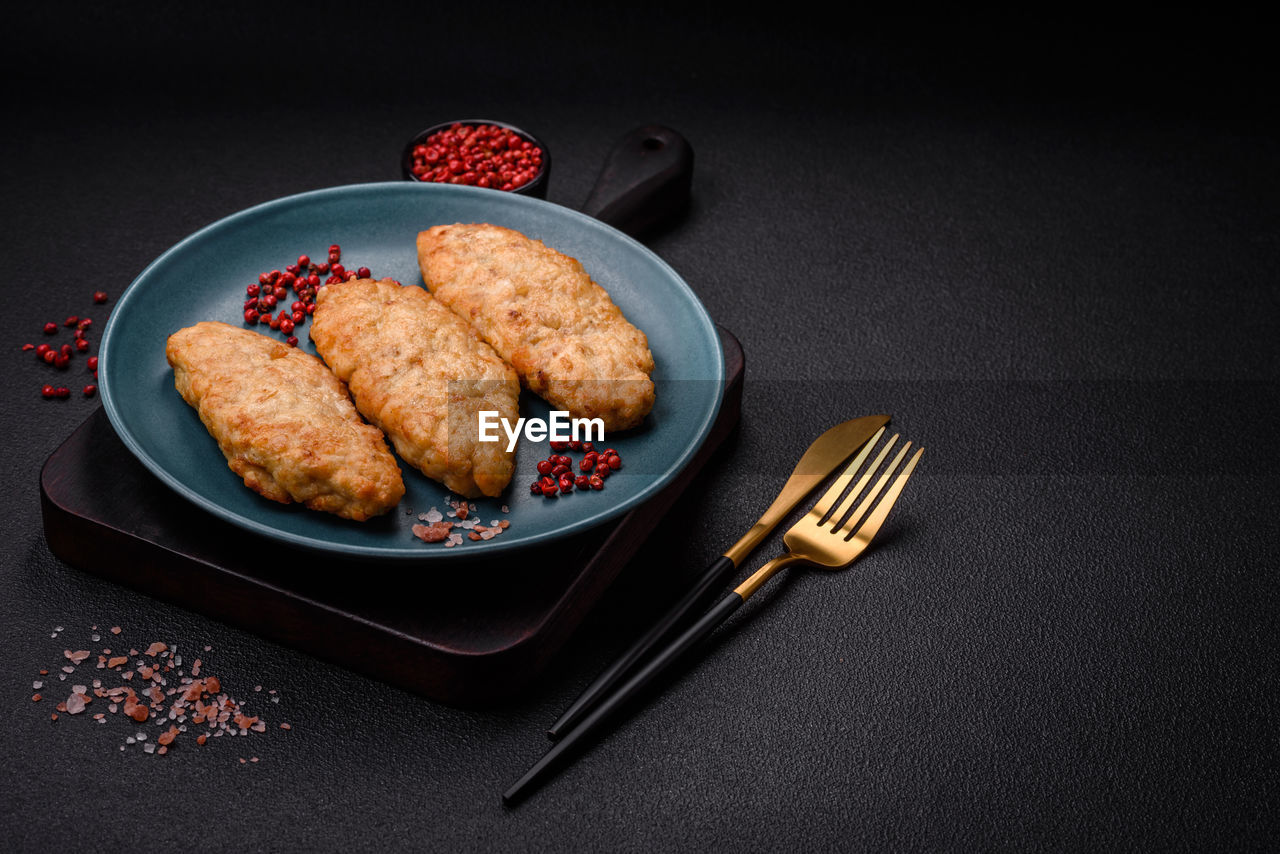 food and drink, food, studio shot, black background, plate, fast food, no people, freshness, indoors, dish, healthy eating, meat, kitchen utensil, fork, meal, fried, still life, high angle view, fruit, wellbeing, eating utensil, korokke