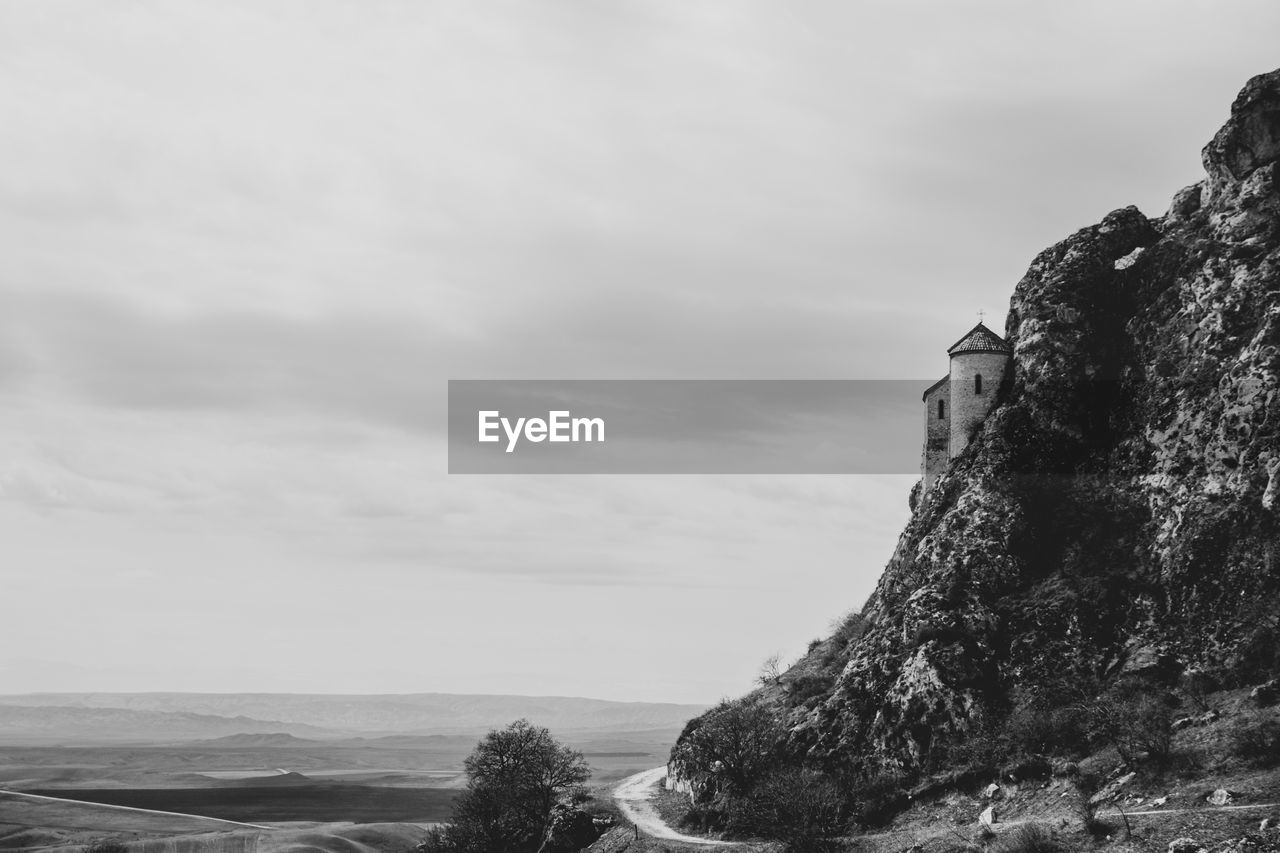 Rock formation by sea against sky