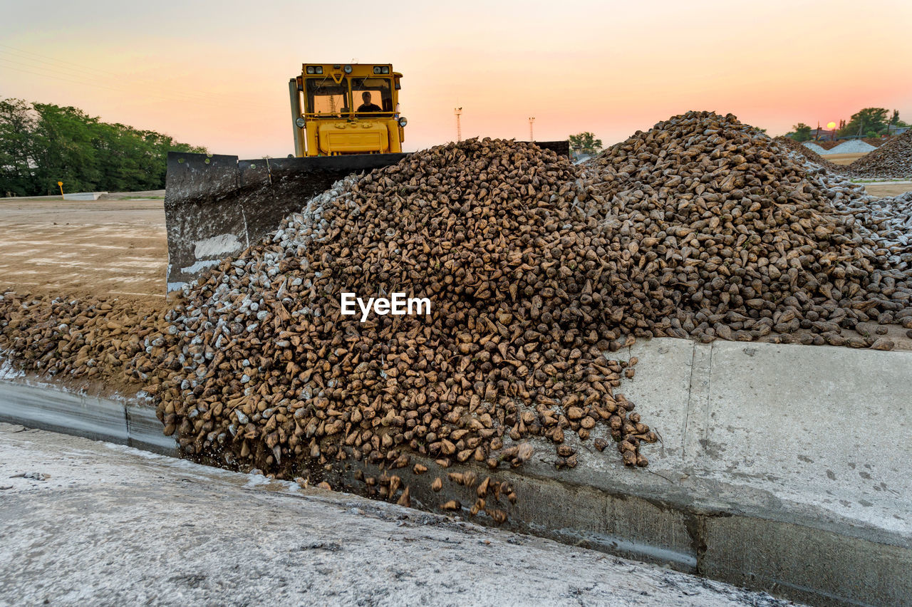 Earth mover at construction site against sky