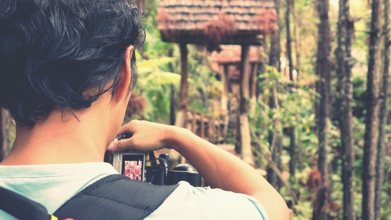 Rear view of young man photographing