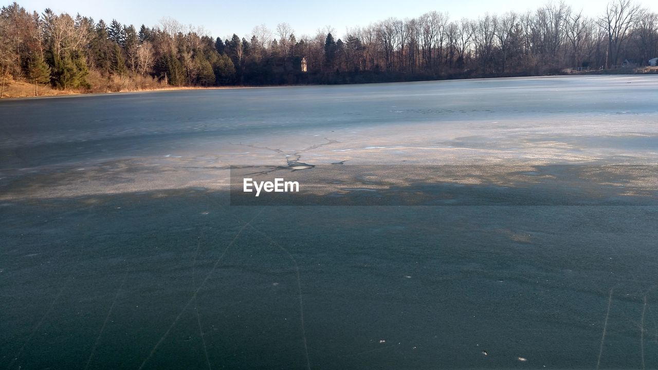 Scenic view of lake against sky during winter