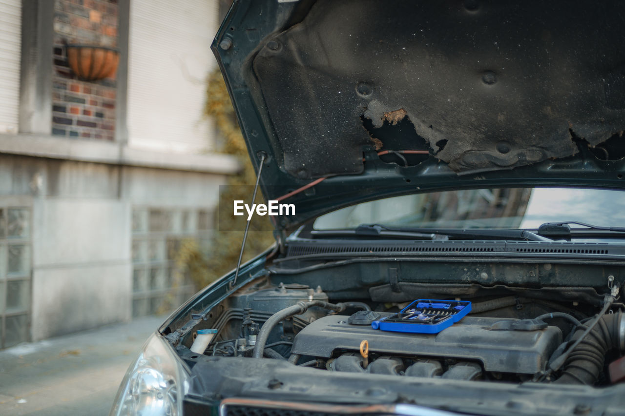 Open hood of a car with a box of tools.