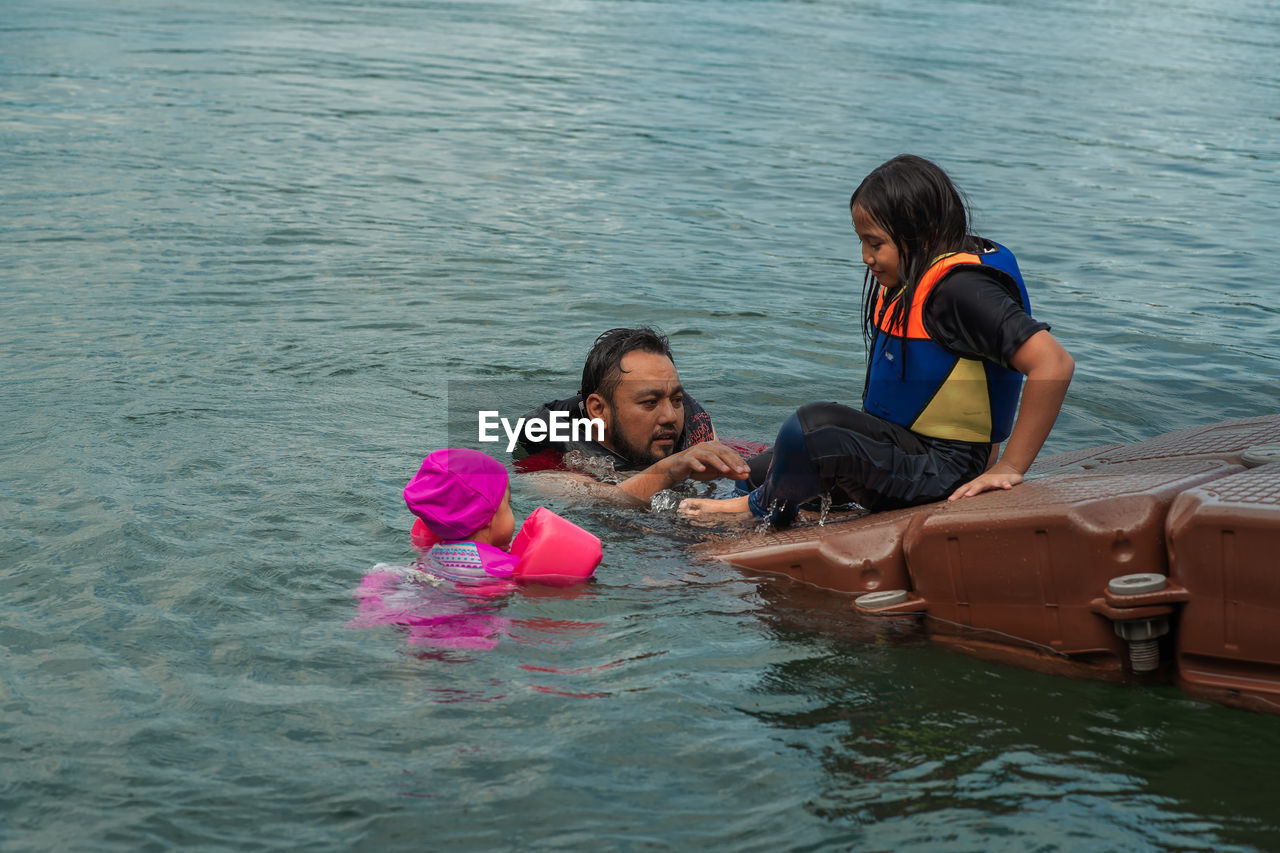 Father and daughters enjoying at lake