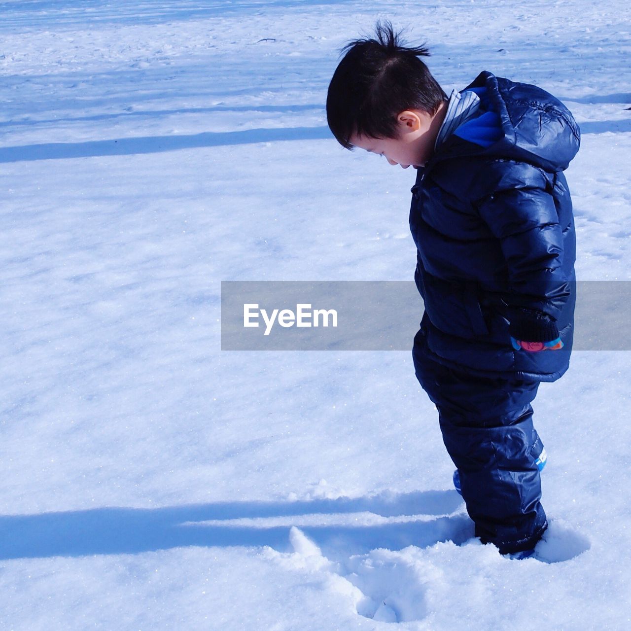 BOY STANDING ON SNOW