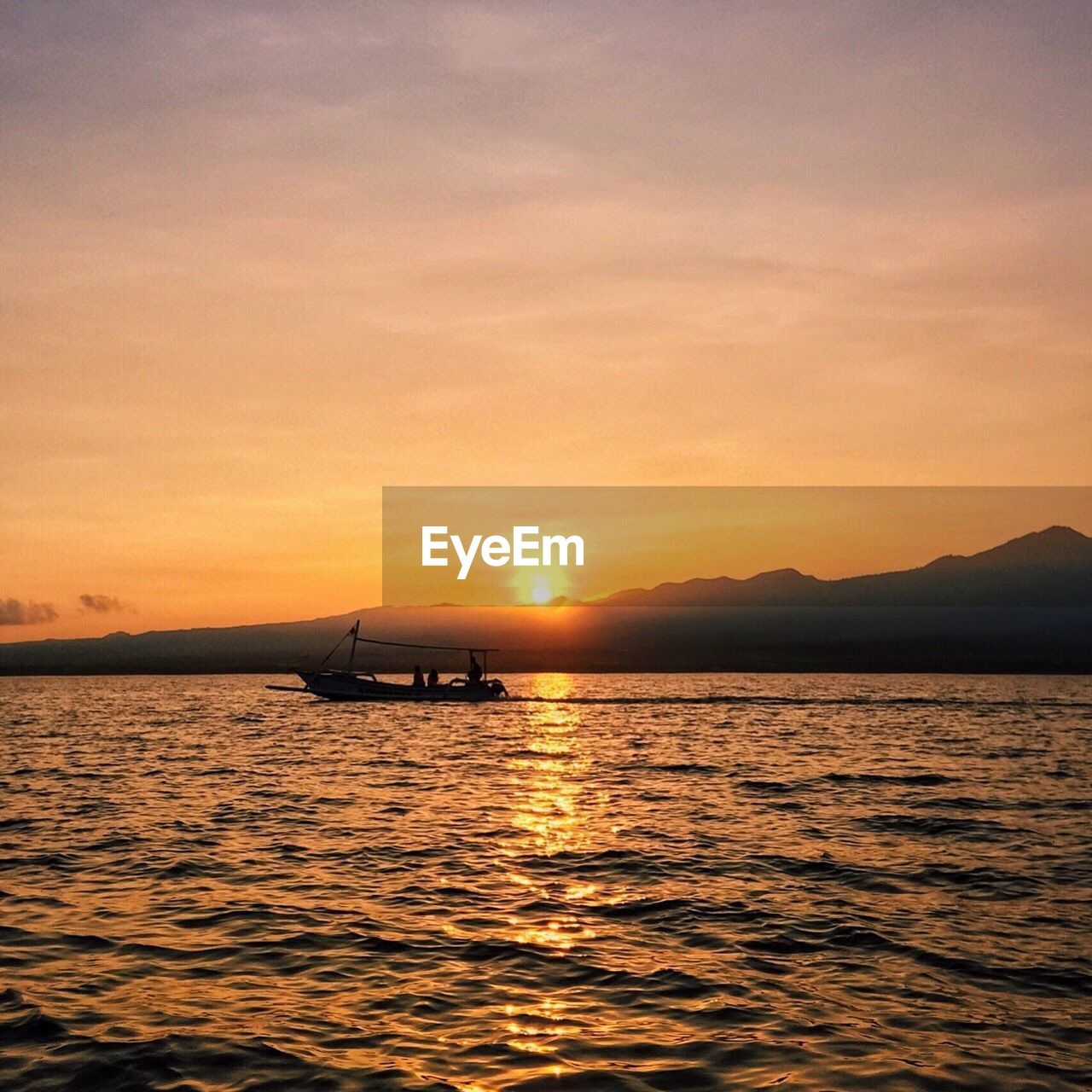 Boat sailing in sea at sunset