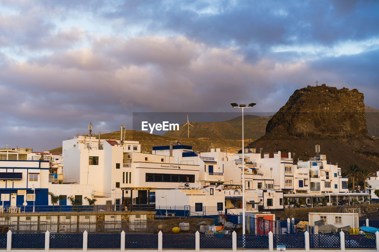 Buildings in city against cloudy sky