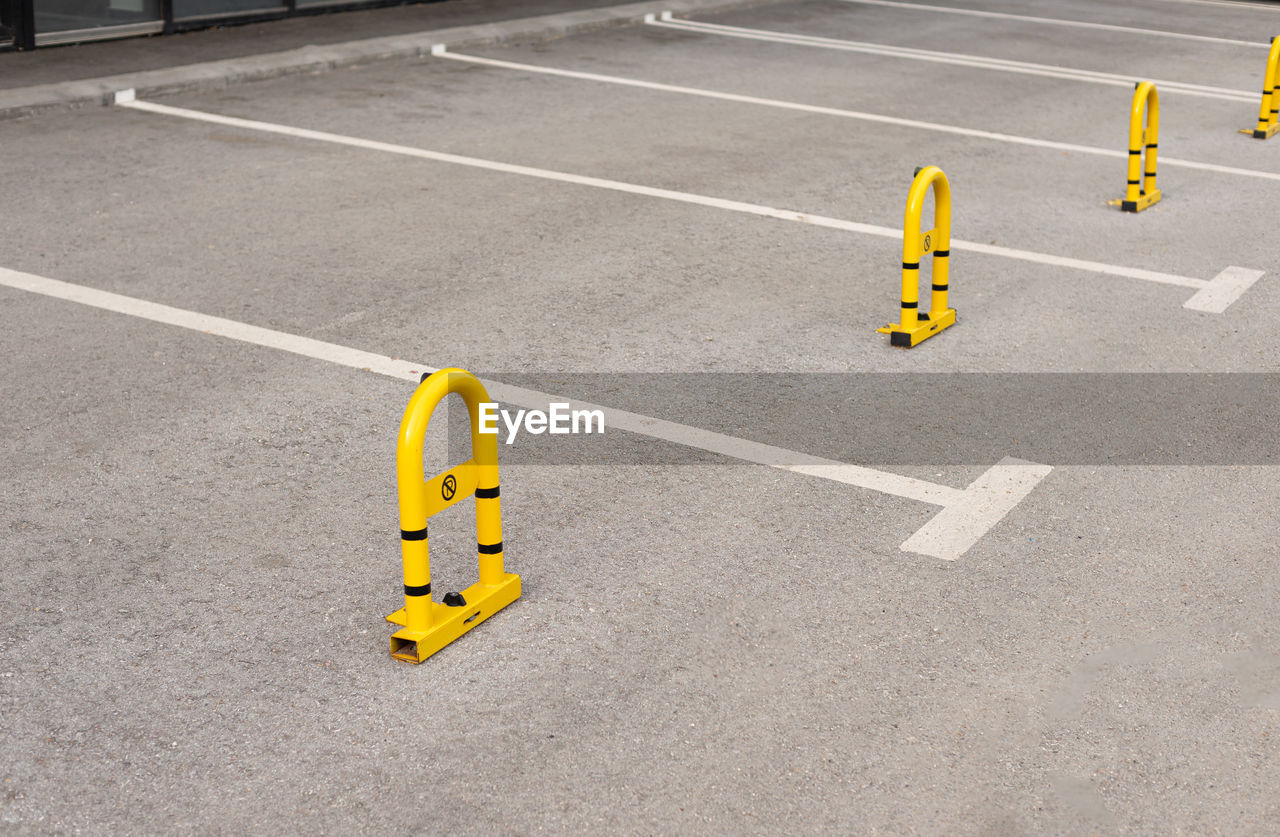 HIGH ANGLE VIEW OF YELLOW ARROW SIGN ON ROAD