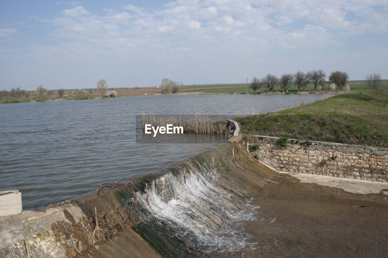 SCENIC VIEW OF RIVER FLOWING THROUGH ROCKS AGAINST SKY