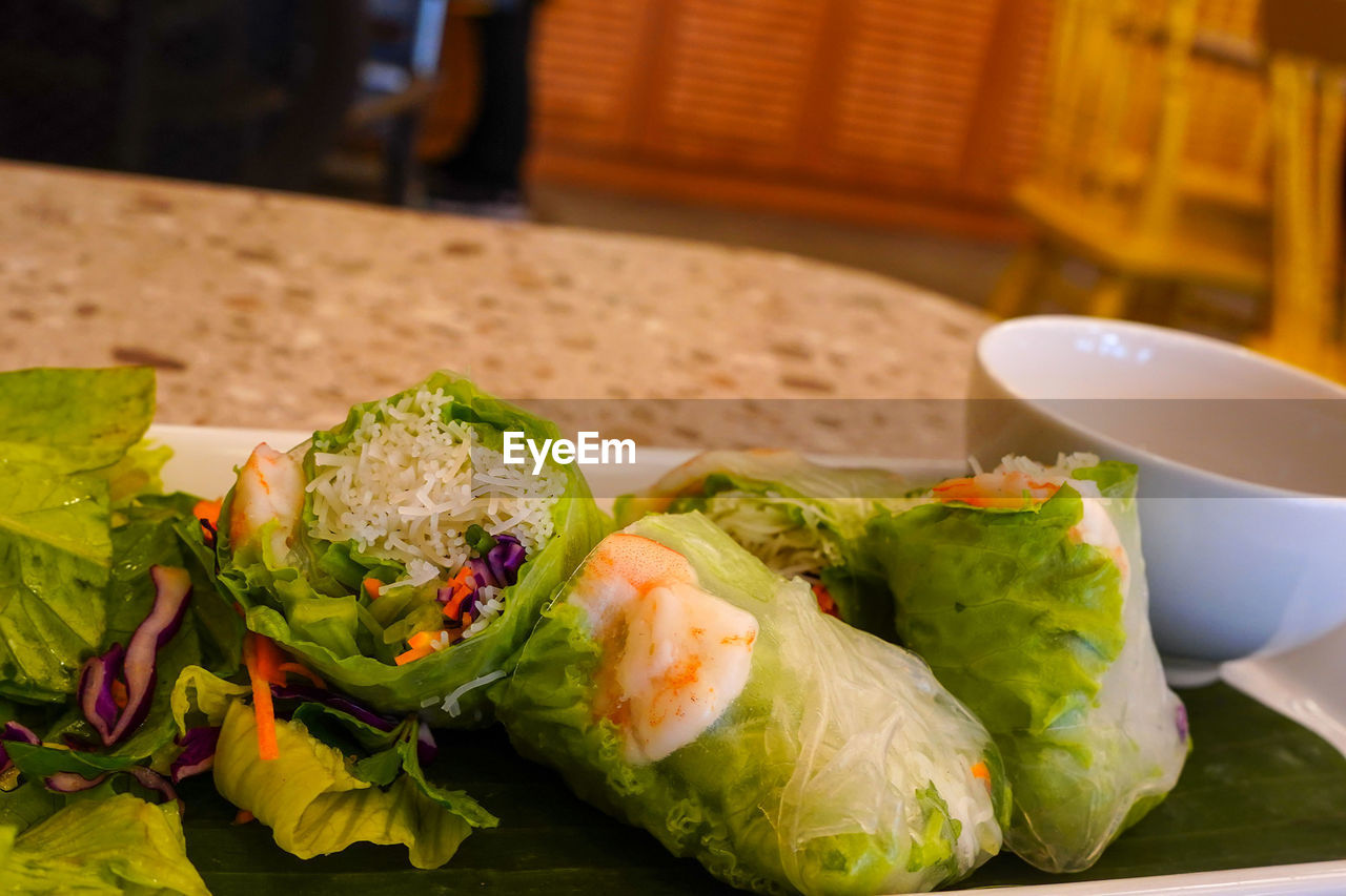 food and drink, food, healthy eating, dish, wellbeing, vegetable, freshness, meal, lunch, fast food, produce, no people, cuisine, lettuce, indoors, sandwich wrap, plate, asian food, salad, close-up, spring roll, still life, table, focus on foreground