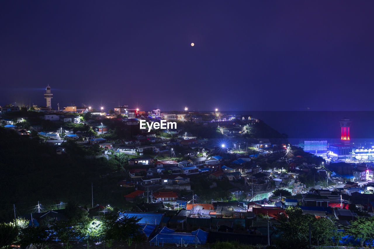 High angle view of illuminated buildings against sky at night