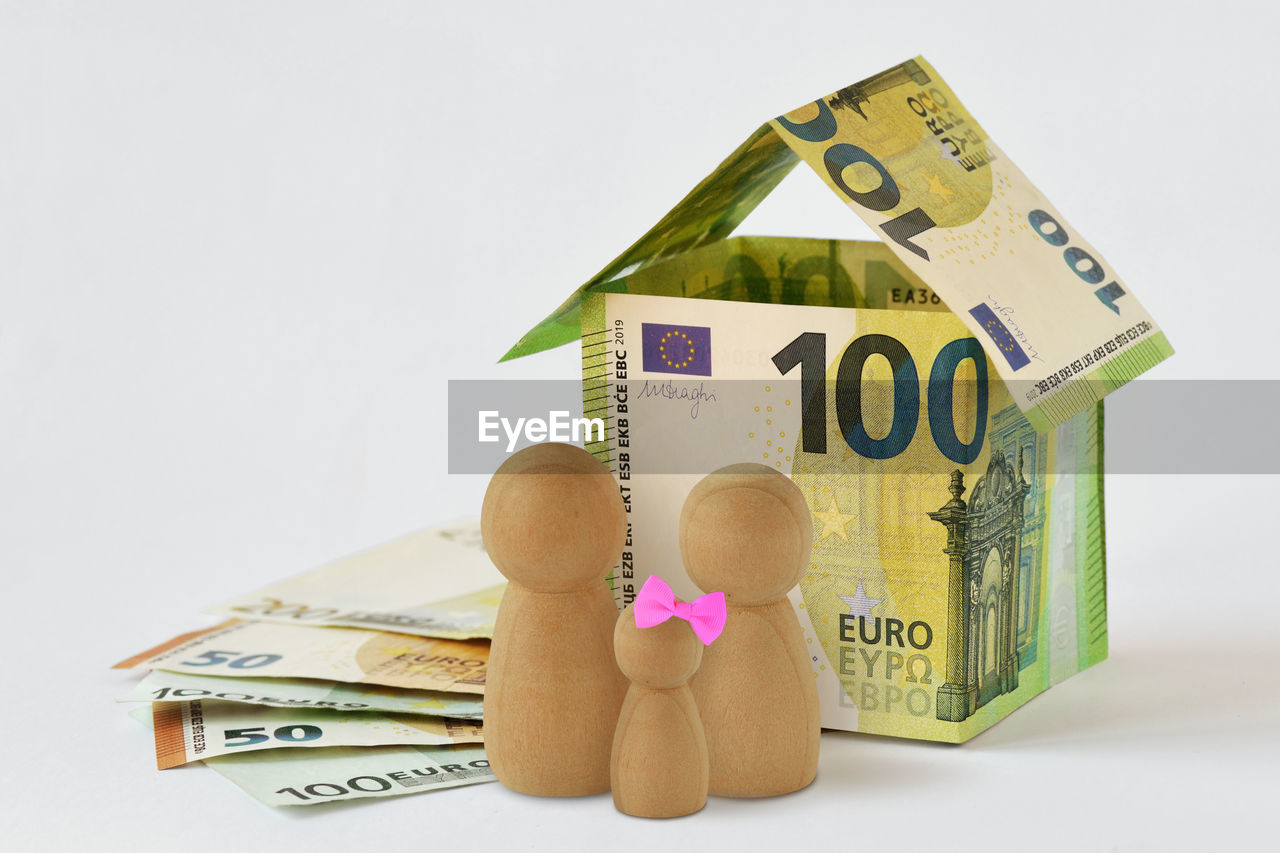 House made of euro banknotes and wooden pawn  - concept of family, home and financial protection