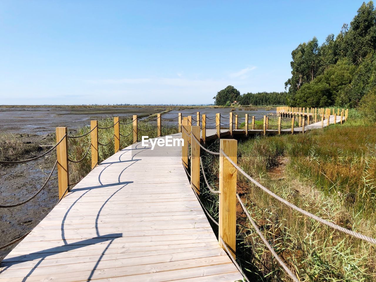 Footbridge over land against sky