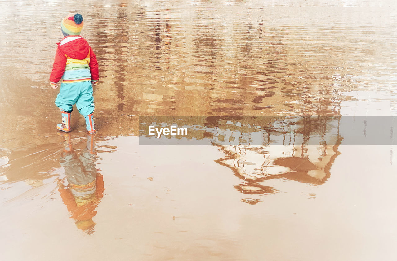 FULL LENGTH OF CHILD STANDING IN LAKE