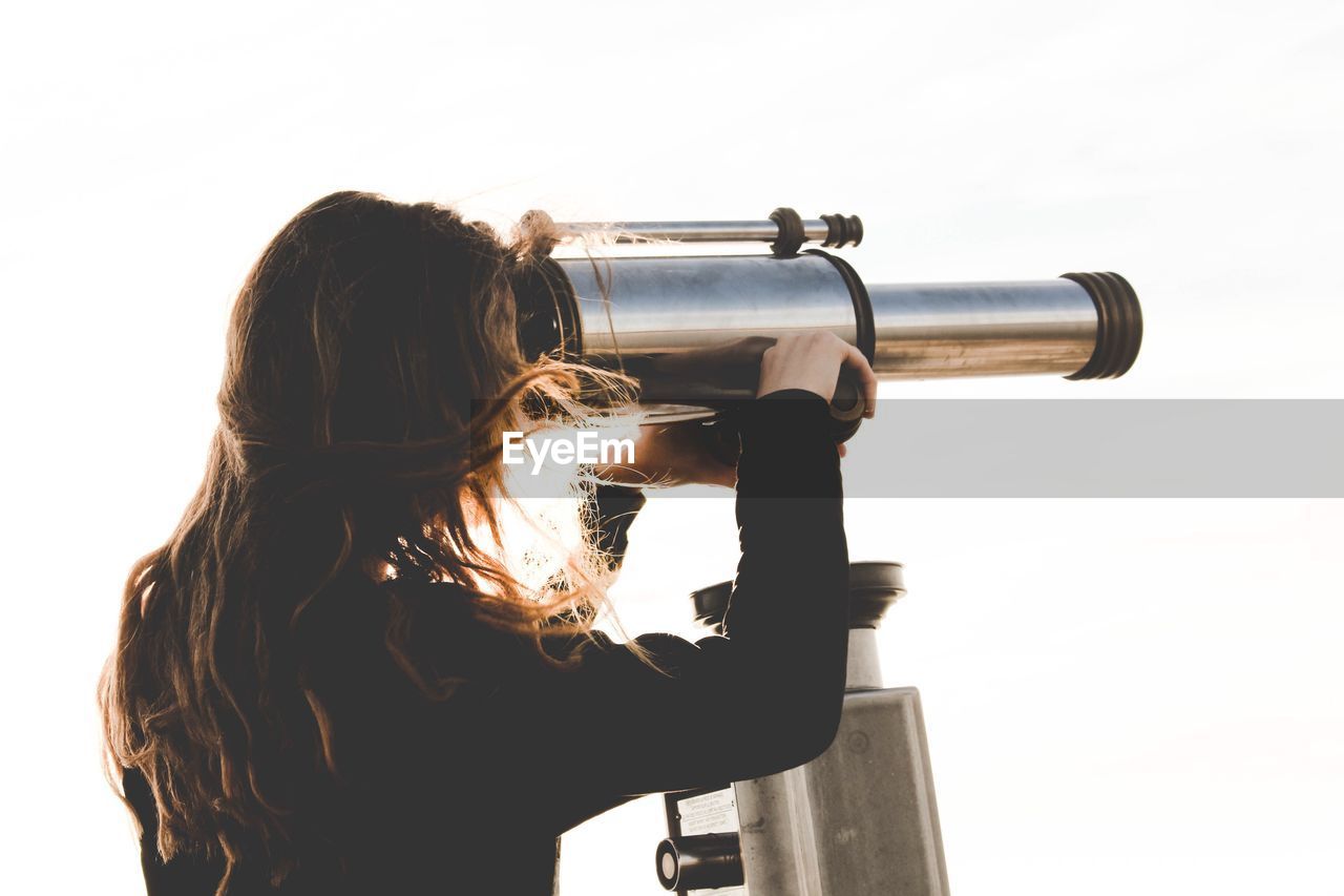 Woman looking through coin-operated binoculars