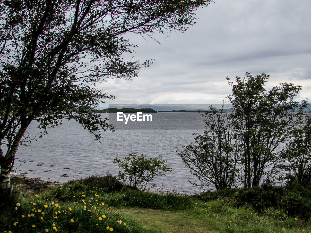 VIEW OF LAKE AGAINST CLOUDY SKY