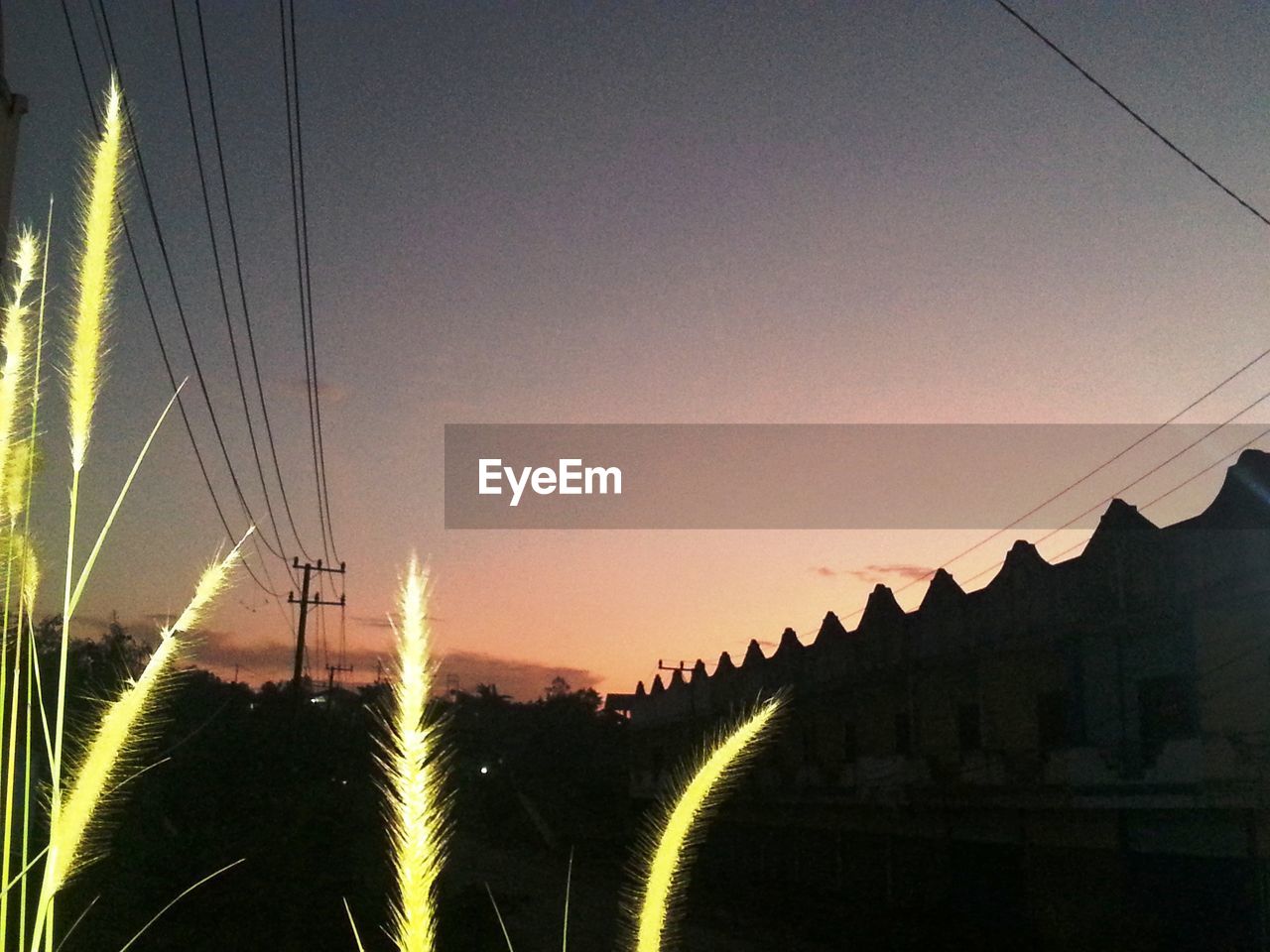 SILHOUETTE ELECTRICITY PYLONS AGAINST SKY