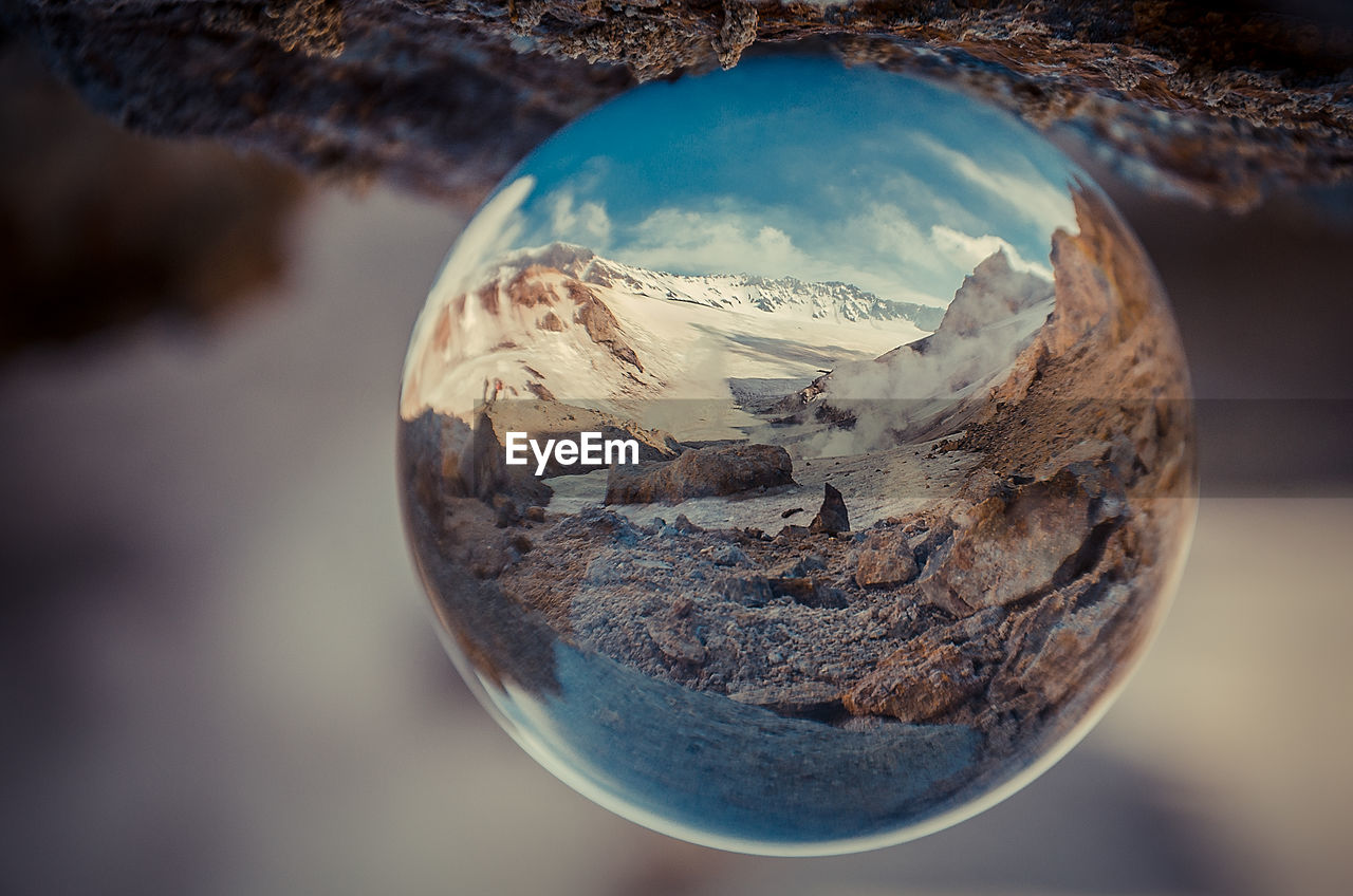 Close-up of crystal ball against mountain