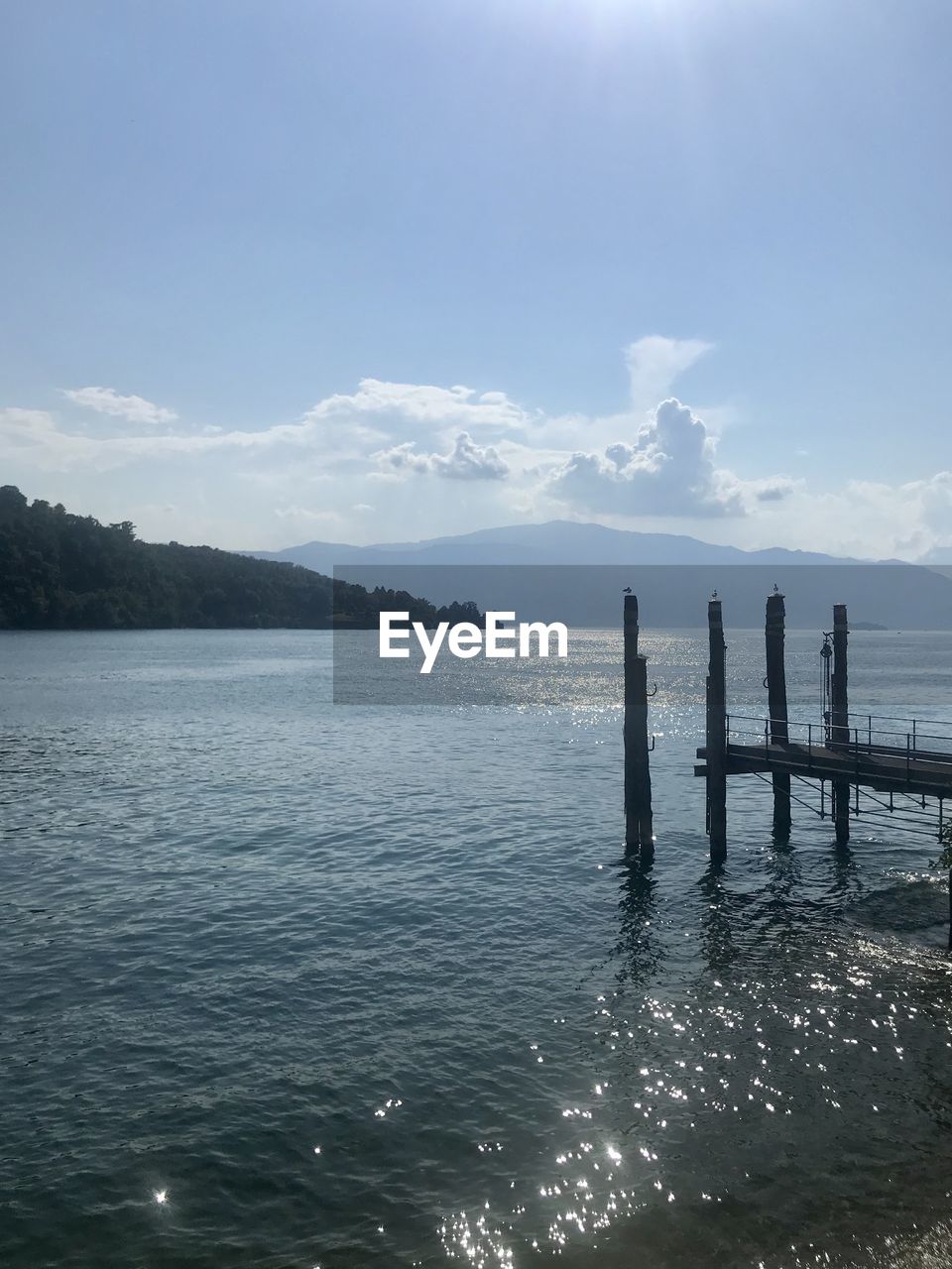 WOODEN POSTS ON SEA AGAINST SKY