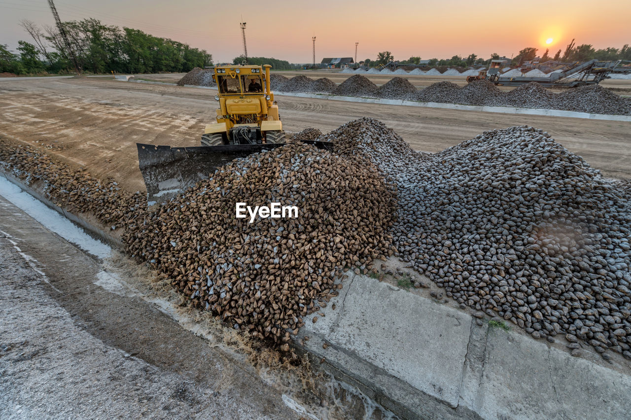 Earth mover at construction site against sky