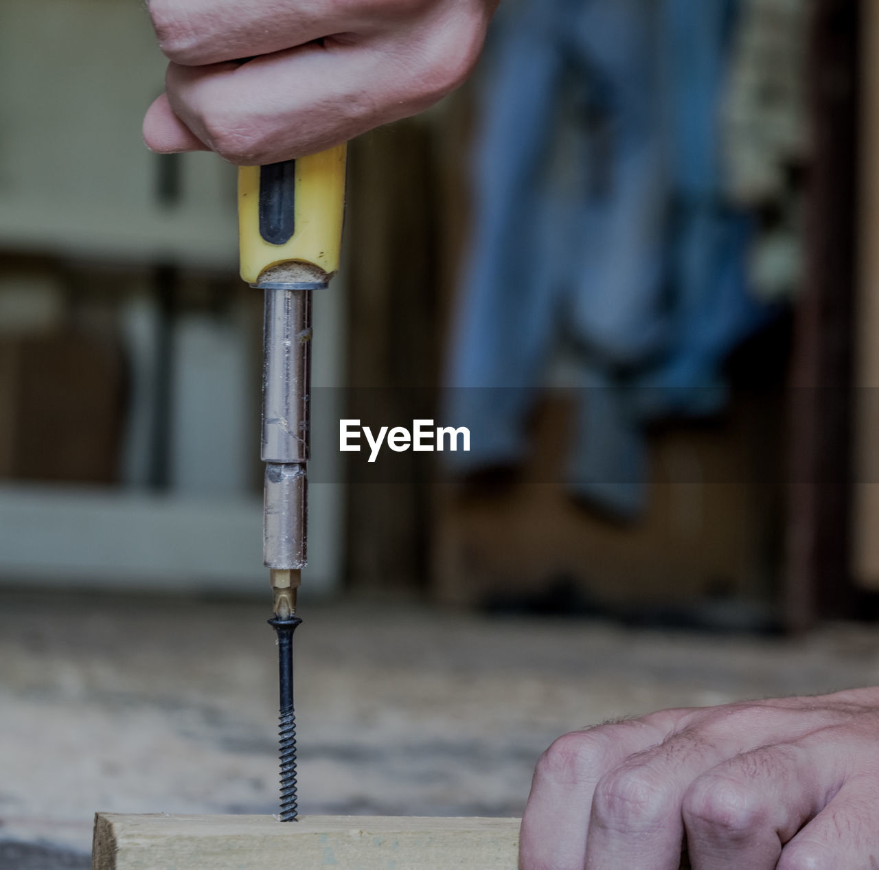 Cropped hands of person drilling in wood