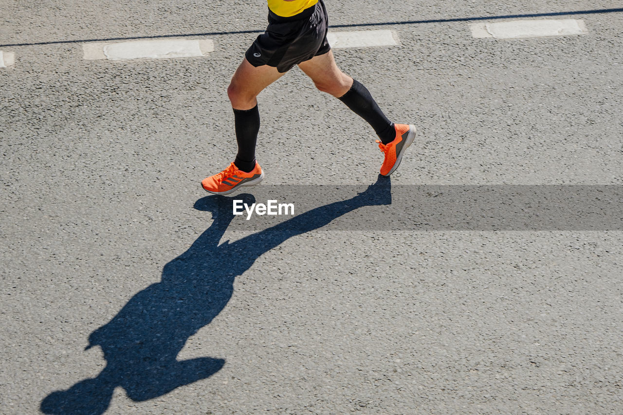 low section of man walking on road