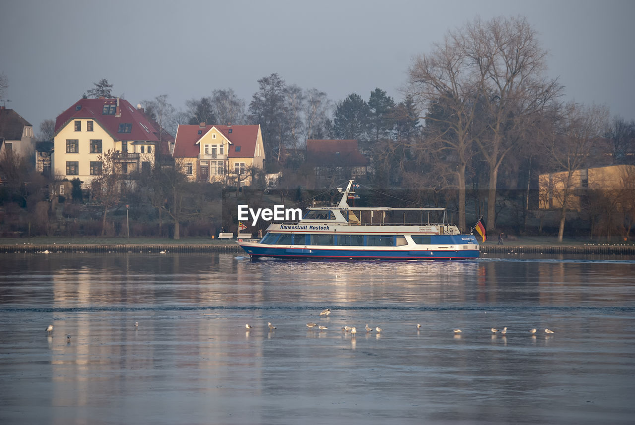 BOATS IN LAKE AGAINST BUILDINGS